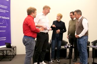 Im Gespräch nach der Podiumsdiskussion: Dr. Fabian Schrumpf, Marcel Roth, Caroline Lindekamp, Prof. Dr. Daniel Loebenberger und Florian Meesmann (v. l.) beim Austausch über die gesellschaftliche und technologische Verantwortung im digitalen Informationszeitalter.