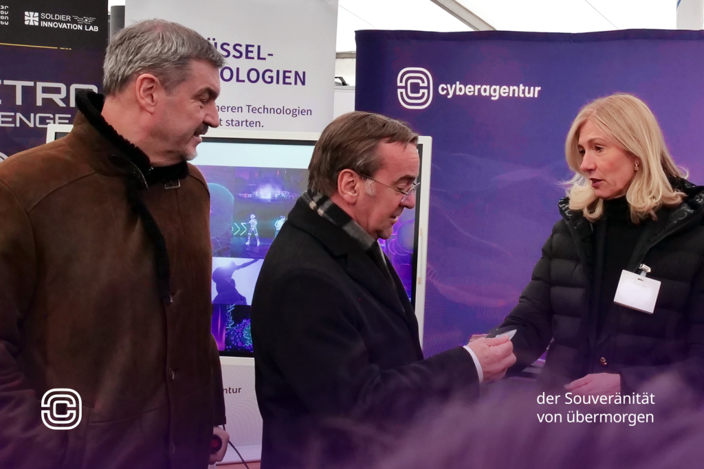 Bundesverteidigungsminister Boris Pistorius im Gespräch mit Bettina Bubnys, kaufmännische Geschäftsführerin der Cyberagentur, am Informationsstand der Agentur; links begleitet von Markus Söder, Ministerpräsident des Freistaats Bayern, anlässlich der Eröffnung des Innovationszentrums der Bundeswehr in Erding.
