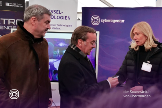 Bundesverteidigungsminister Boris Pistorius im Gespräch mit Bettina Bubnys, kaufmännische Geschäftsführerin der Cyberagentur, am Informationsstand der Agentur; links begleitet von Markus Söder, Ministerpräsident des Freistaats Bayern, anlässlich der Eröffnung des Innovationszentrums der Bundeswehr in Erding.